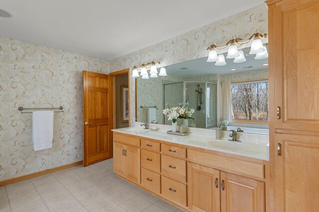 bathroom featuring a shower stall, wallpapered walls, baseboards, and a sink