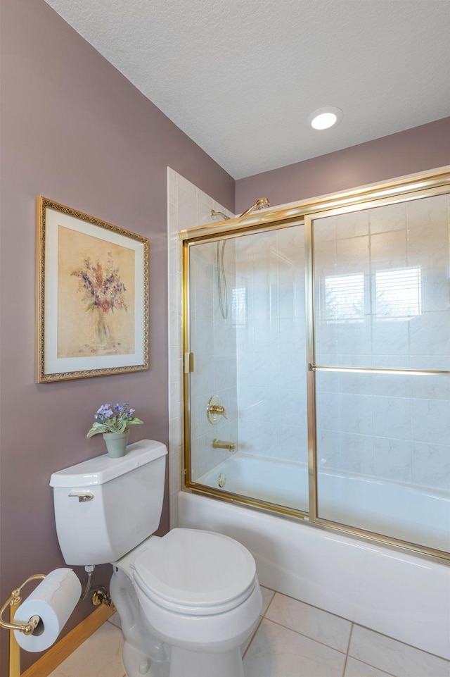 bathroom featuring a textured ceiling, bath / shower combo with glass door, toilet, and tile patterned flooring