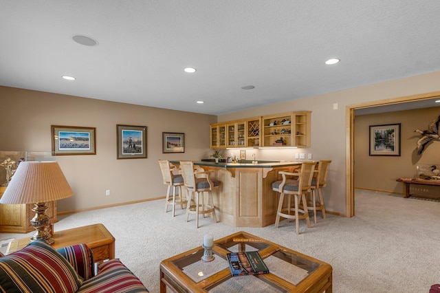 living area featuring wet bar, recessed lighting, light colored carpet, and baseboards