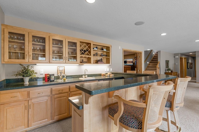 bar featuring recessed lighting, a sink, stairs, a textured ceiling, and light carpet