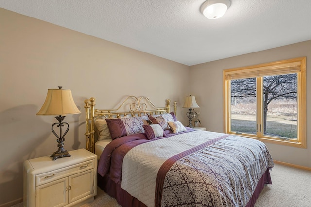 bedroom featuring light colored carpet, baseboards, and a textured ceiling