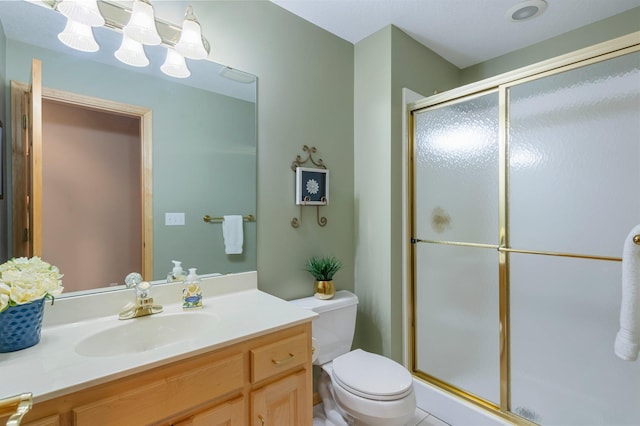 bathroom with toilet, a stall shower, and vanity