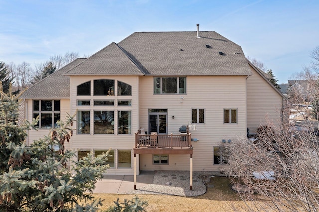 back of house featuring a patio area and roof with shingles