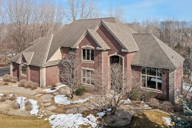 view of front of property featuring brick siding and a shingled roof