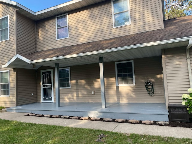 view of front of home with roof with shingles and a porch