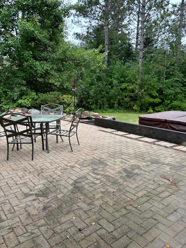 view of patio with outdoor dining space and a covered hot tub