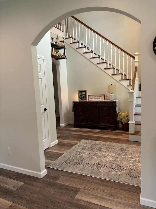 staircase with baseboards and wood finished floors