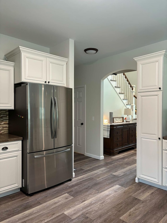 kitchen with white cabinetry, dark countertops, dark wood-style flooring, and freestanding refrigerator