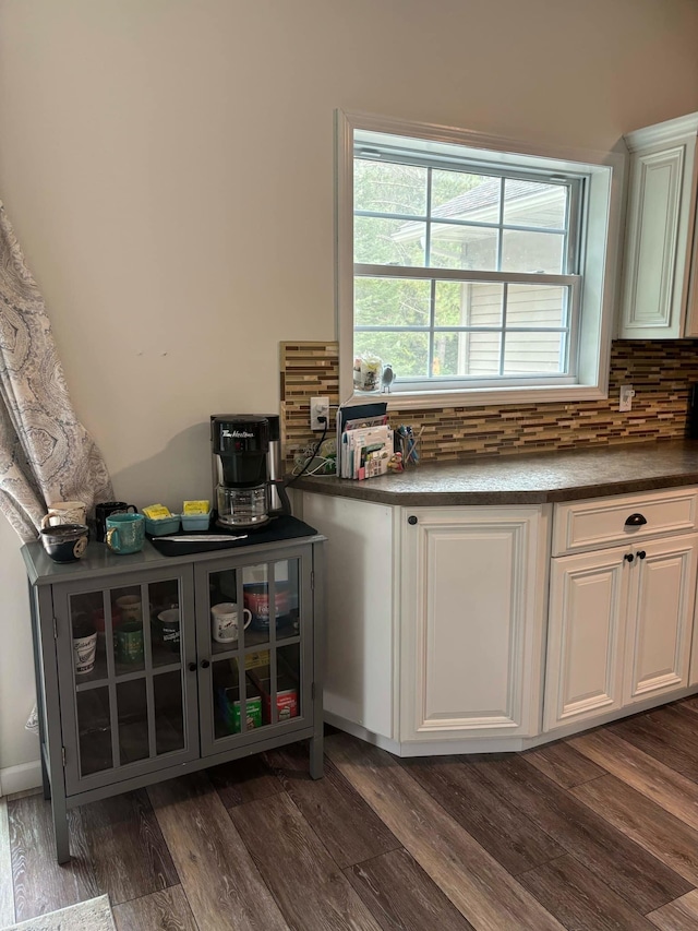 interior space featuring backsplash, dark wood-style floors, and white cabinetry