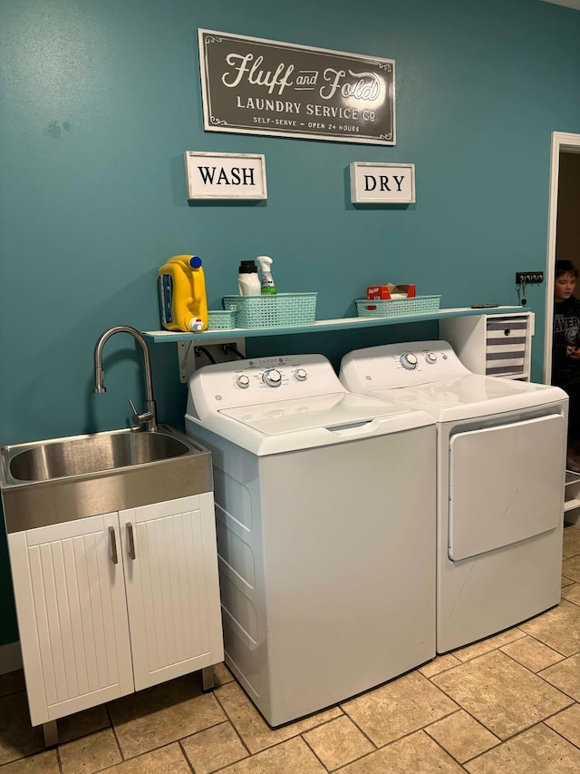 laundry area featuring washing machine and clothes dryer, laundry area, and a sink