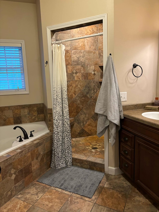 full bath with stone tile flooring, a tile shower, a bath, and vanity