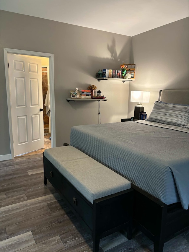 bedroom with dark wood-type flooring and baseboards