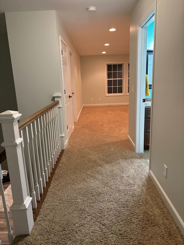 hall featuring recessed lighting, baseboards, an upstairs landing, and carpet flooring