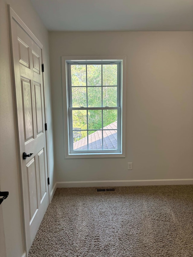 unfurnished room featuring baseboards, carpet floors, and visible vents