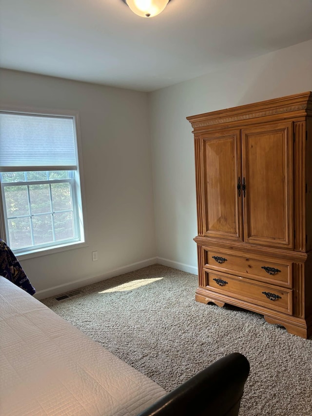 carpeted bedroom featuring visible vents and baseboards