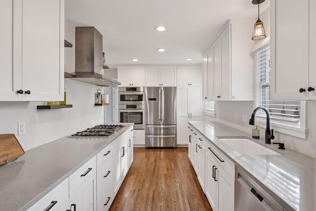 kitchen with a sink, island exhaust hood, white cabinetry, and stainless steel appliances