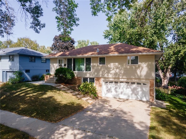 view of front of home with fence, driveway, an attached garage, a front lawn, and brick siding