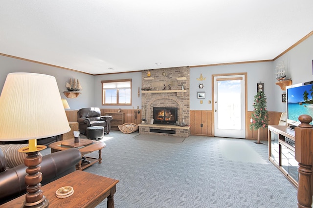 carpeted living area with crown molding, a brick fireplace, wooden walls, and wainscoting