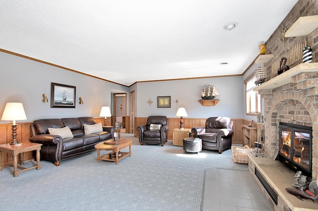 living room featuring crown molding, a brick fireplace, carpet flooring, and wainscoting