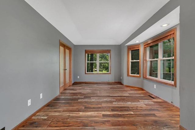 empty room featuring recessed lighting, wood finished floors, and baseboards