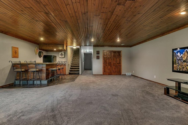 unfurnished living room featuring a bar, wooden ceiling, stairway, and carpet