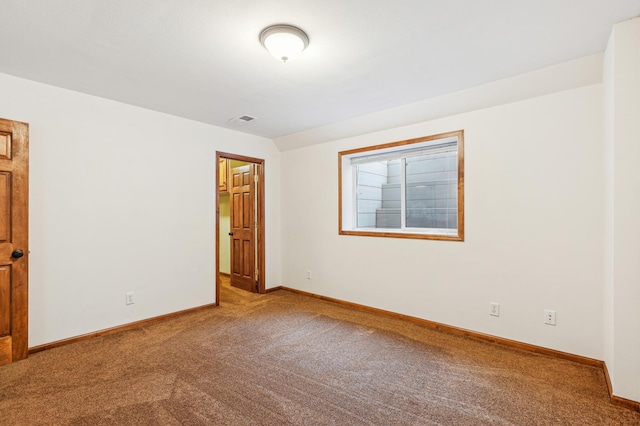 carpeted spare room featuring visible vents and baseboards