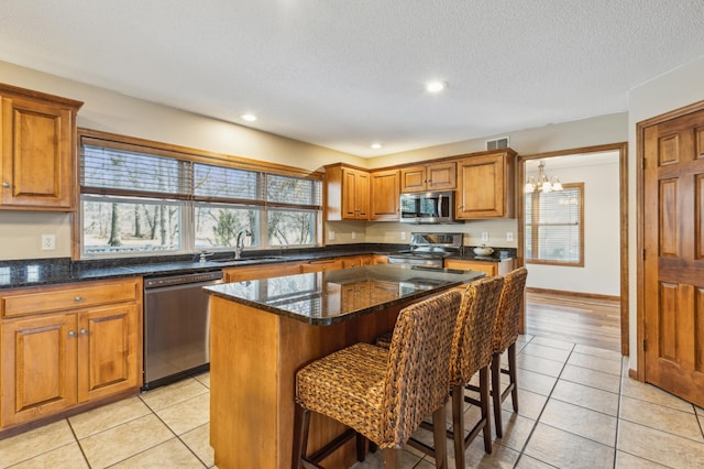 5492 Garden Hills Dr, Saint Augusta, MN 56301 - kitchen with visible vents, appliances with stainless steel finishes, a kitchen breakfast bar, brown cabinetry, and a sink