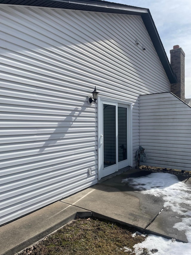 view of home's exterior with a patio area and a chimney