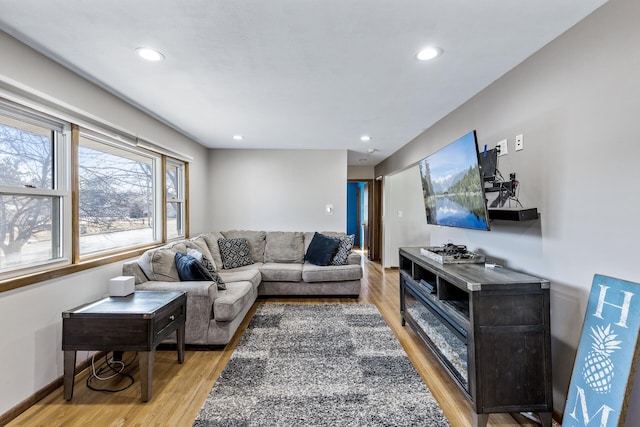 living room featuring recessed lighting, baseboards, and light wood-style flooring