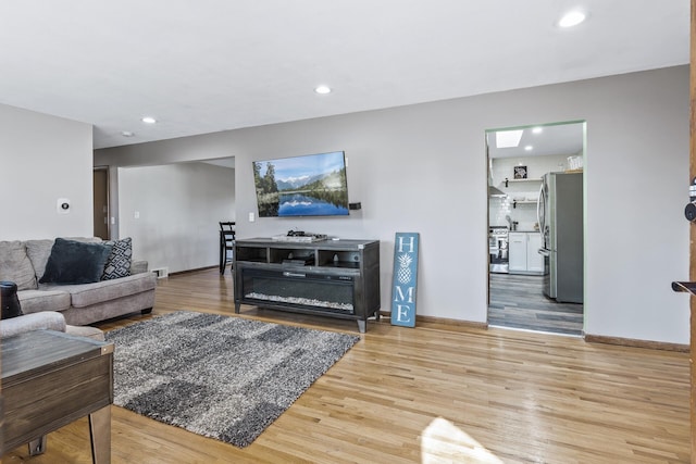 living area with light wood finished floors, recessed lighting, and baseboards