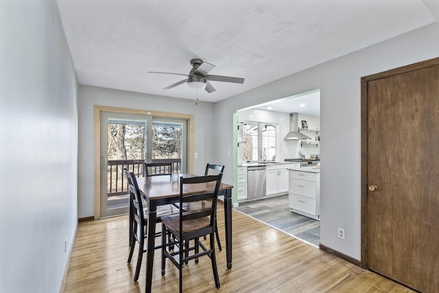 dining room with light wood-type flooring, baseboards, and ceiling fan