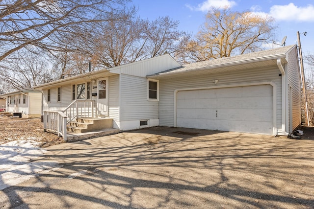 view of front facade featuring aphalt driveway, an attached garage, and roof with shingles