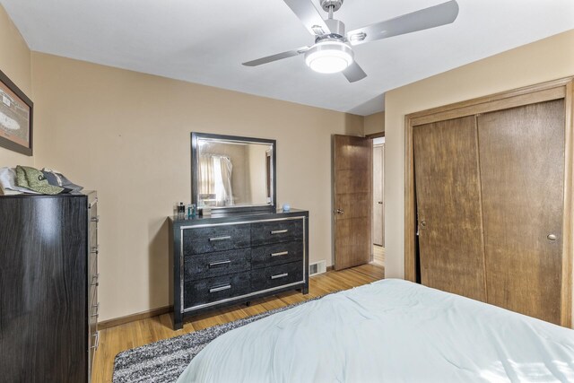 bedroom featuring visible vents, ceiling fan, baseboards, light wood-style floors, and a closet