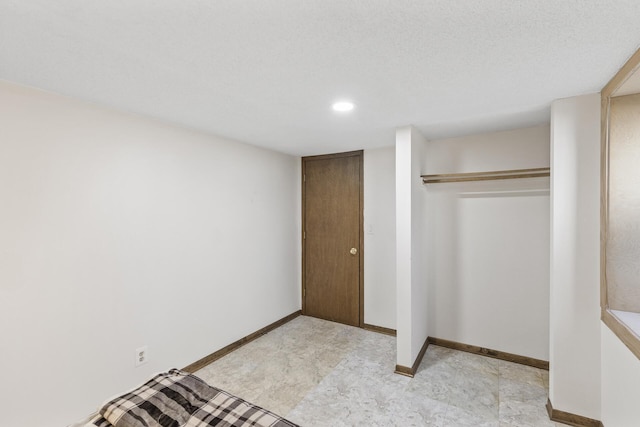 unfurnished bedroom with baseboards and a closet