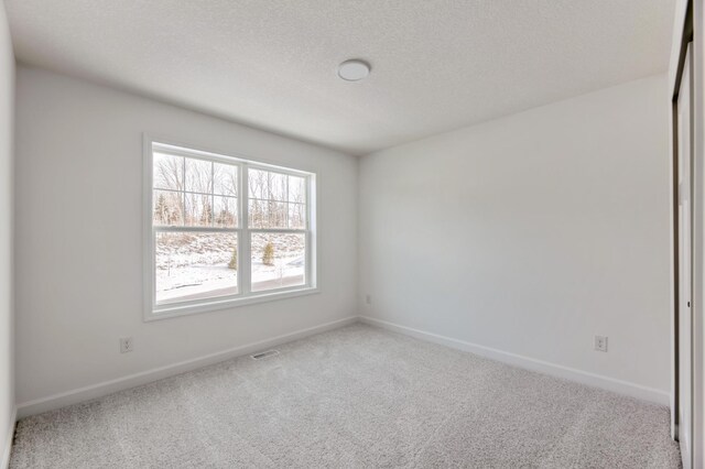 empty room featuring visible vents, baseboards, and carpet flooring