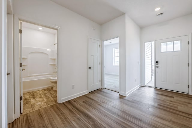 foyer entrance with recessed lighting, visible vents, baseboards, and wood finished floors