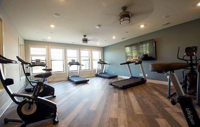 workout area featuring visible vents, a ceiling fan, a textured ceiling, wood finished floors, and baseboards