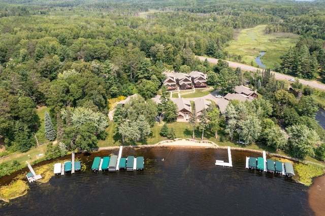 drone / aerial view with a forest view and a water view