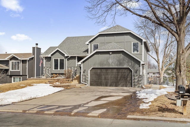 view of front facade featuring brick siding, driveway, an attached garage, and a shingled roof