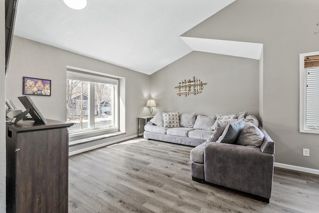 living area with vaulted ceiling, wood finished floors, and baseboards