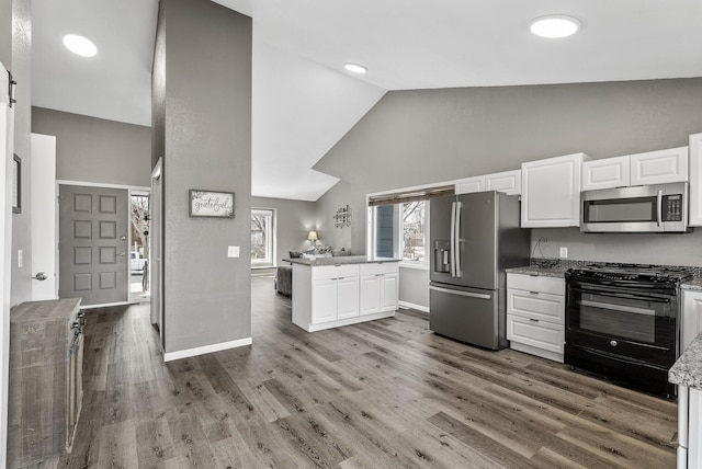 kitchen with appliances with stainless steel finishes, white cabinetry, and wood finished floors