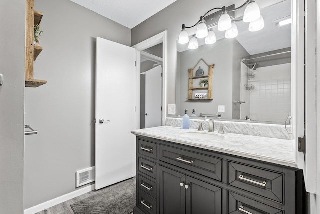 full bath featuring visible vents, baseboards, walk in shower, wood finished floors, and vanity