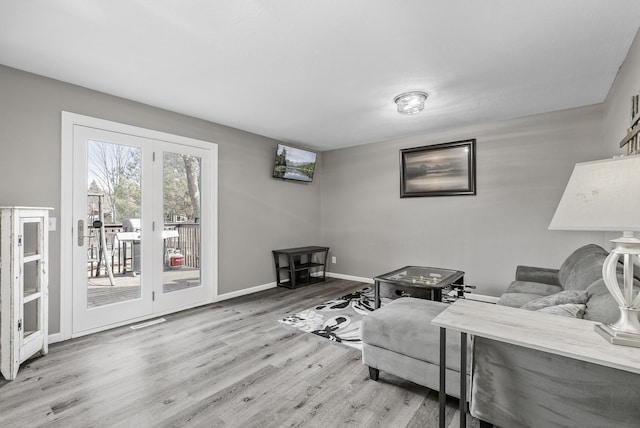 living room featuring visible vents, baseboards, and wood finished floors