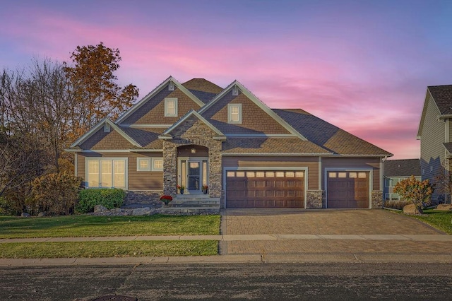 craftsman inspired home featuring a garage, stone siding, a front yard, and driveway