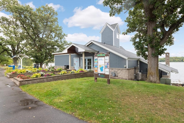 view of front of house featuring a front yard, a vegetable garden, and central AC unit