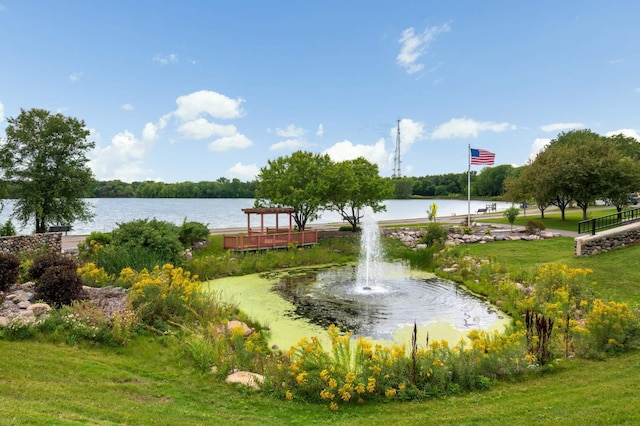 view of home's community featuring a lawn and a water view