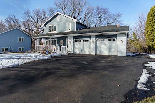 view of front of home with aphalt driveway, a porch, an attached garage, and brick siding