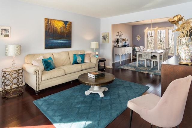 living area with a notable chandelier, wood finished floors, and baseboards