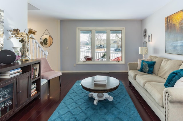 living area with baseboards and dark wood finished floors