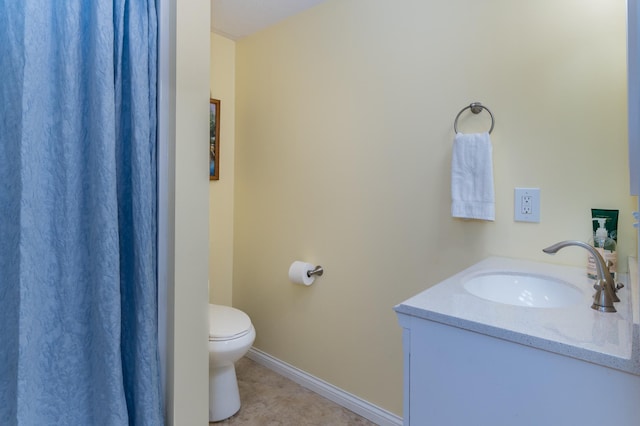 bathroom featuring vanity, tile patterned floors, toilet, and baseboards